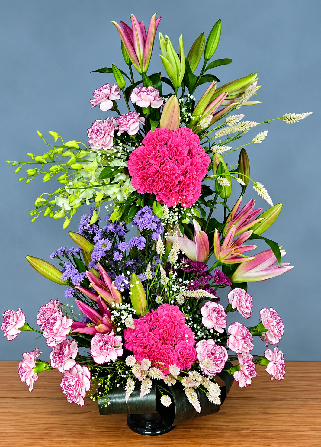 Pink carnation and lily flower arrangement with lavender blooms baby's breath and green foliage by WhiteFields