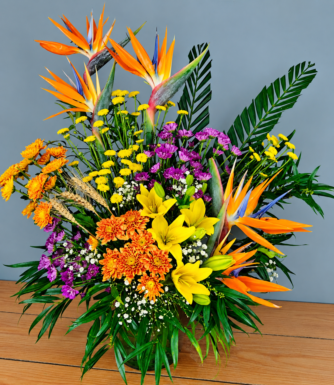 Tropical Sunburst Bouquet with Bird of Paradise flowers, yellow lilies, orange chrysanthemums and fresh greenery by Whitefields