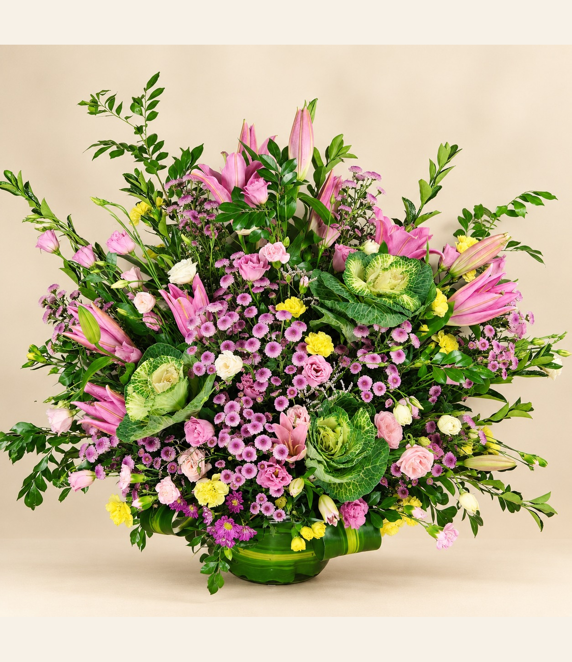 Pink lily and rose floral arrangement with yellow flowers, purple blooms and ornamental greenery by Whitefields