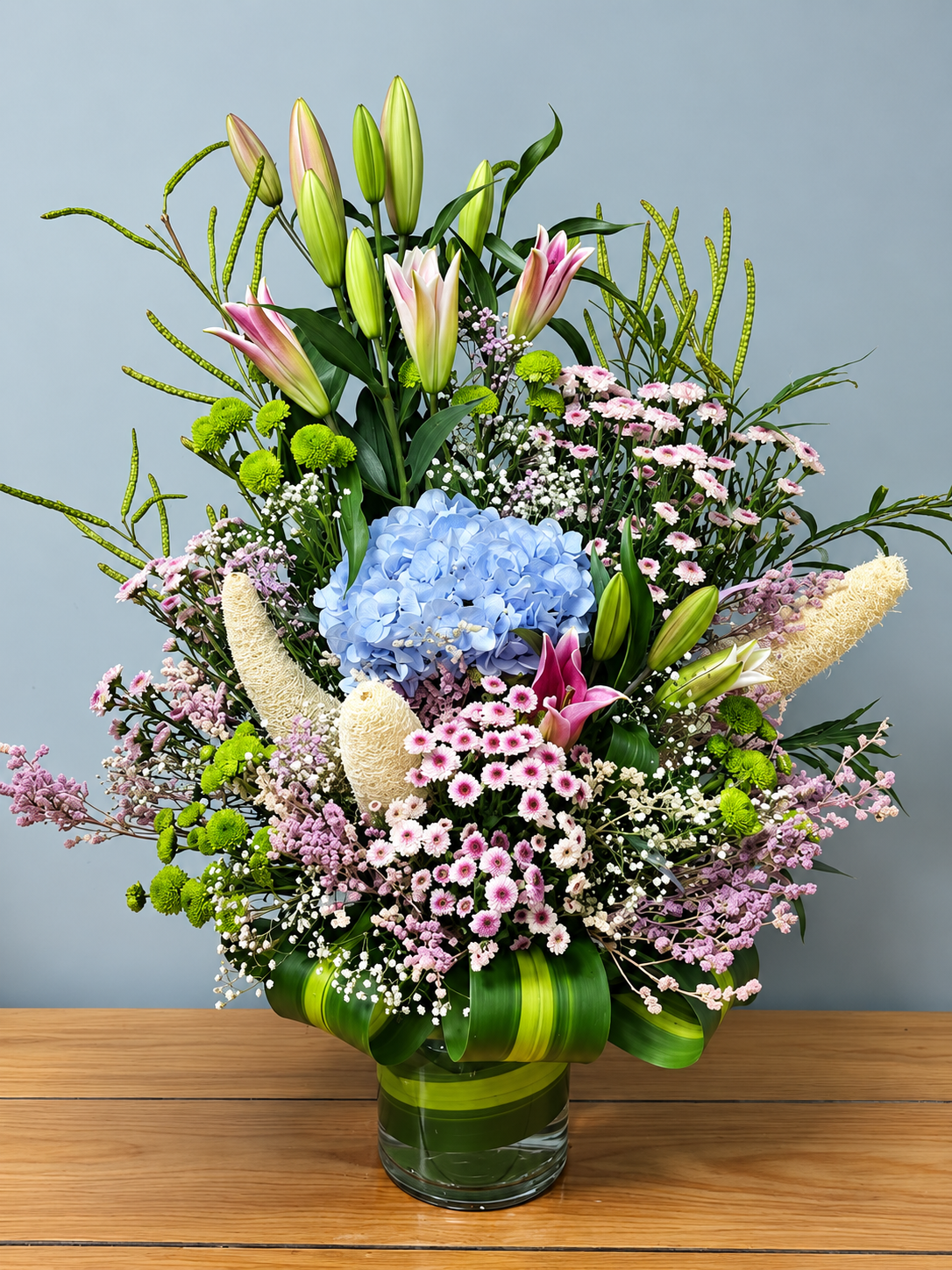Azure Petal Symphony blue hydrangea and pink lily flower arrangement with delicate pastel blooms by WhiteFields
