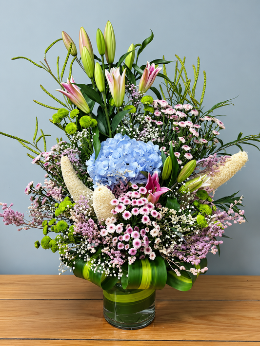 Azure Petal Symphony blue hydrangea and pink lily flower arrangement with delicate pastel blooms by WhiteFields