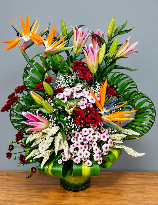 Exotic mixed flower arrangement with orange bird of paradise, pink lilies, white blooms and green foliage by WhiteFields
