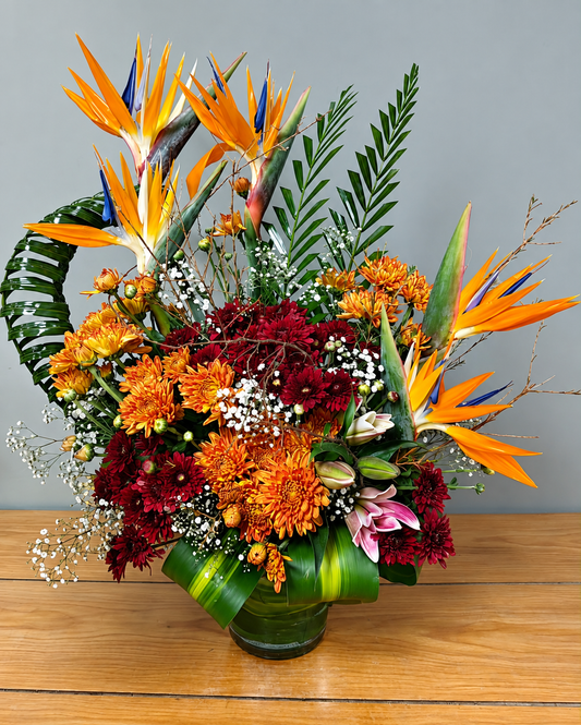 Exotic flower bouquet with orange Bird of Paradise, burgundy chrysanthemums, lilies and tropical greenery by WhiteFields