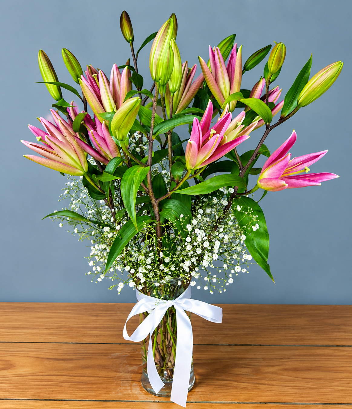 Pink lily flower arrangement with white baby's breath and green foliage by WhiteFields