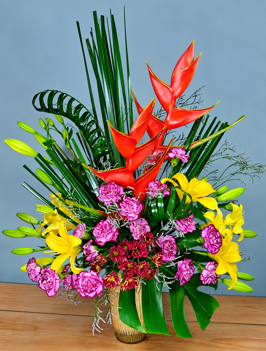 Tropic Glow exotic flower bouquet with red heliconia, yellow lilies and pink carnations for flower delivery in Gurgaon
