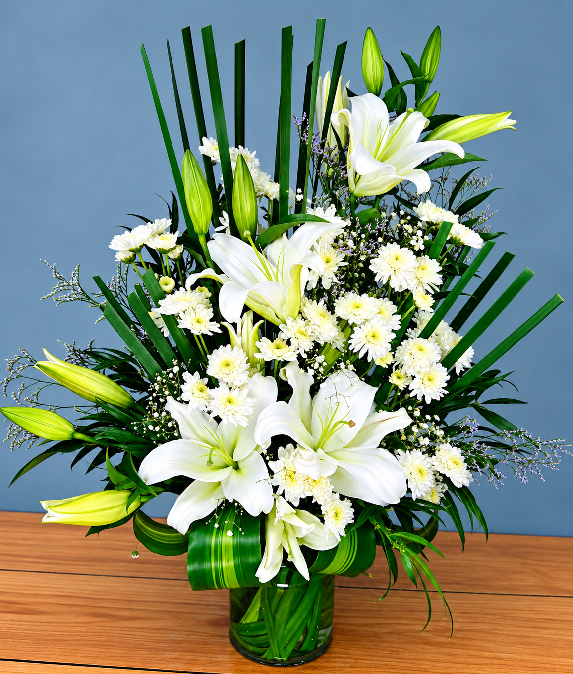 White Lily Elegance bouquet with white lilies, white chrysanthemums and fresh green foliage by Whitefields
