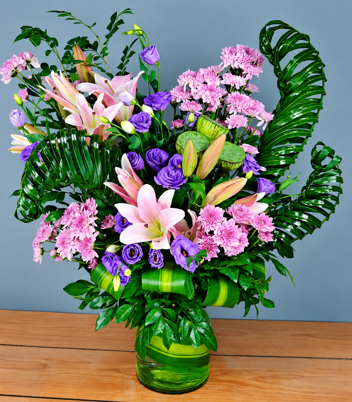 Lilac Lily Luxe Bouquet with pink lilies, purple roses, pink chrysanthemums and green foliage by Whitefields